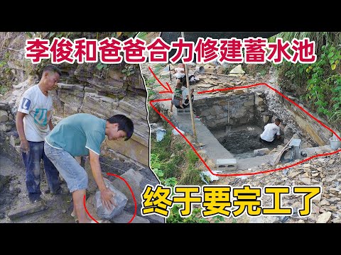 修建了几个月的蓄水池 在爸爸的帮助下终于要完工了。李俊也学会了砌墙