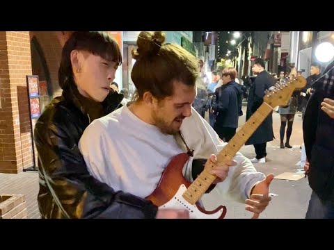 Street performer surprised by guitarist passing by in Korea